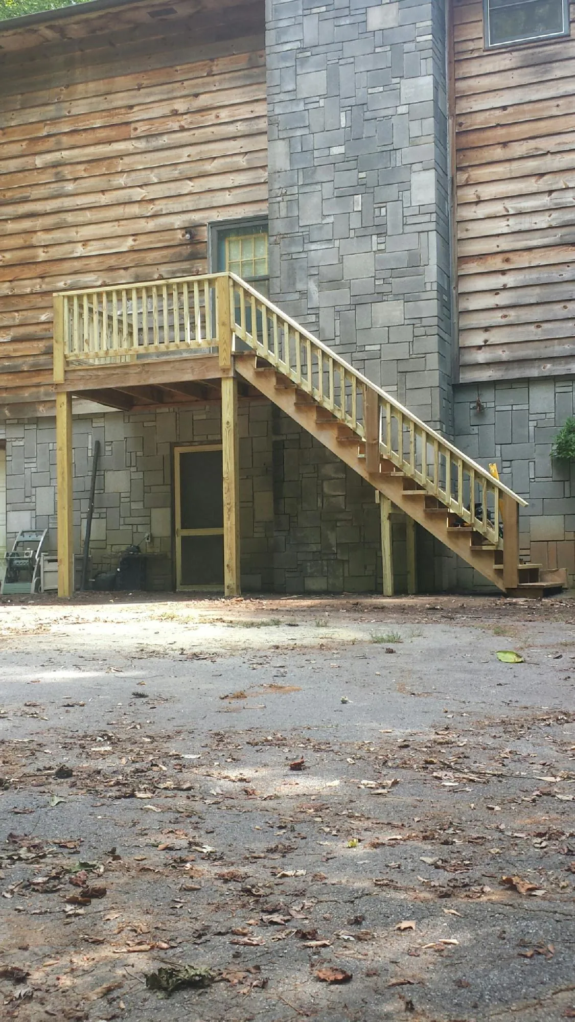 New pressure treated deck and stair landing on a log home in Irwin